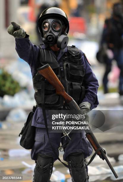 An anti-riot policeman gestures during a dispersal operation against anti-government protesters near Government House in Bangkok on October 7, 2008....