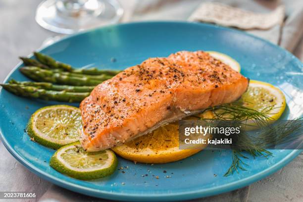 grilled fillet of salmon with asparagus served on a plate - gebackener lachs stock-fotos und bilder