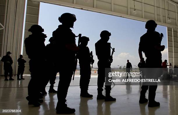 Federal Police officers wait for the arrival of alleged members of the drug cartel "Los Zetas" for their presentation to the press at the Command...