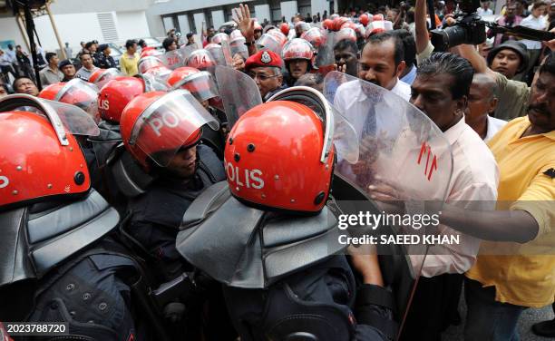 Malaysian Police push back a crowd from the main entrance of a mortuary at a hospital in Kuala Lumpur on January 28, 2009. Malaysian police arrested...