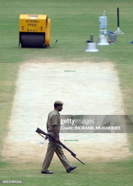 An Indian policeman walks across the pitch of the M.A. Chidambaram stadium in Chennai on December 8, 2008. England are to arrive in Chennai later in...