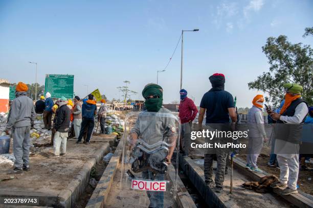 Farmer is holding a police shield, which was confiscated during a confrontation with the authorities, to protect himself against police tear gas and...