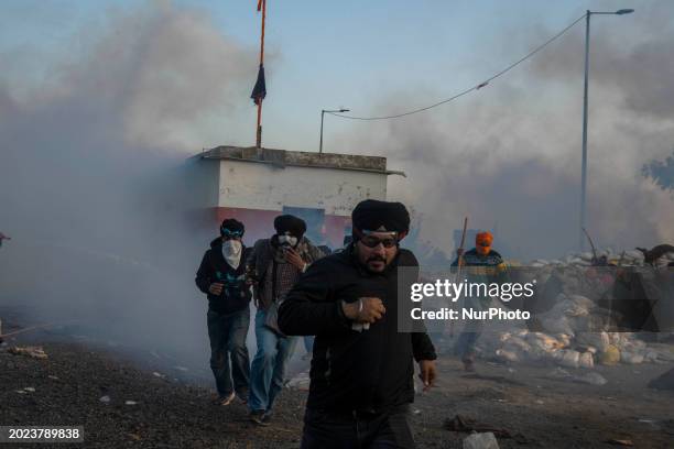 Farmers are running for cover as police fire tear gas during a protest in Shambhu barrier, a border crossing between Punjab and Haryana states,...