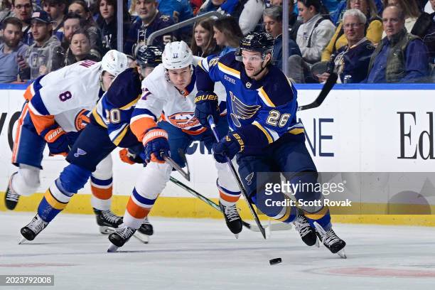 Nathan Walker of the St. Louis Blues controls the puck as Matt Martin of the New York Islanders pressures on February 22, 2024 at the Enterprise...