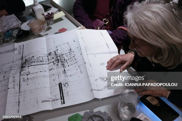 Woman checks the house plan of an apartment that she plans to live in together with a roommate in Athens on February 14 in what is called "solidarity...