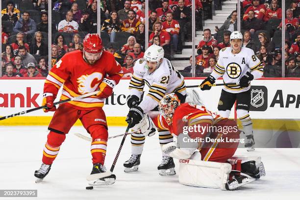 Rasmus Andersson and Jacob Markstrom of the Calgary Flames defend against James Van Riemsdyk of the Boston Bruins during the second period of an NHL...