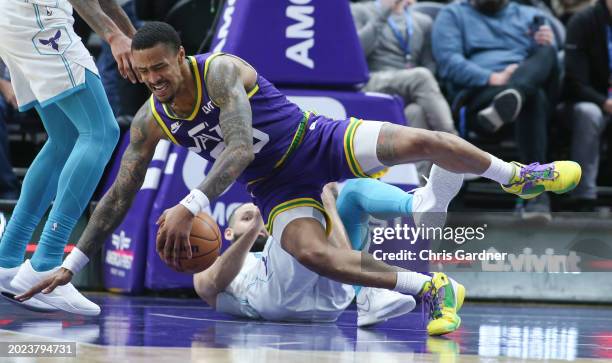 John Collins of the Utah Jazz falls to the floor after being fouled by Cody Martin of the Charlotte Hornets during the second half of their game at...