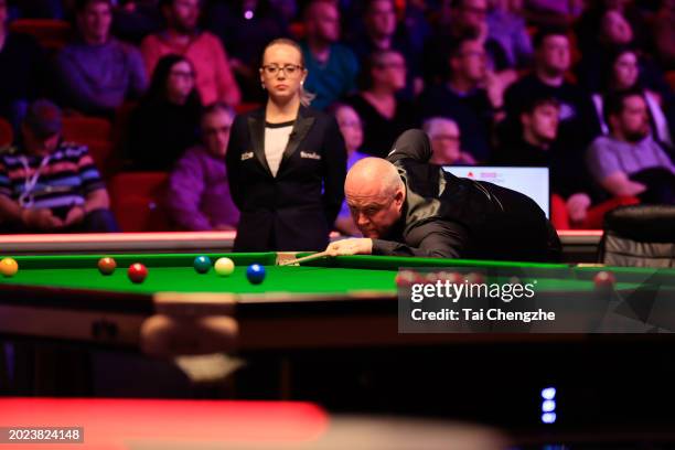 John Higgins of England plays a shot in the first round match against Ding Junhui of China on day one of 2024 Players Championship at Telford...