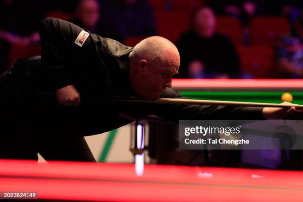 John Higgins of England plays a shot in the first round match against Ding Junhui of China on day one of 2024 Players Championship at Telford...