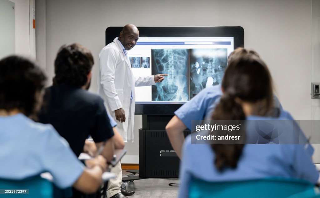 Doctor teaching a class and showing an x-ray on a touch screen