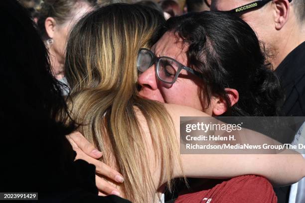 Friends of the victims cry and hug one another after a healing march to remember shooting victims Samuel Knopp of Parker and Celie Rain Montgomery of...