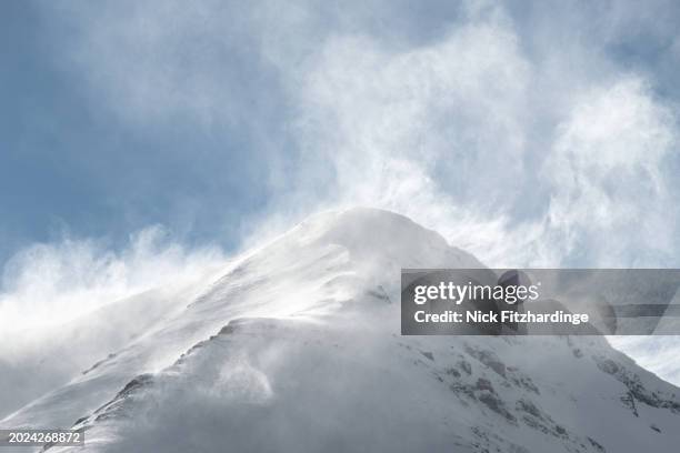 snow being blown off a windy mountain top in the canadian rockies, alberta, canada - ventarrón fotografías e imágenes de stock