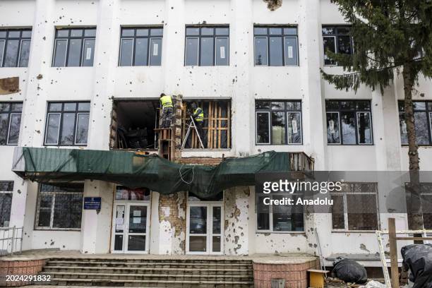 Ukrainian men try to repair the building as Kyiv Oblast, surrounding the capital of Ukraine, still bears the scars of the war as the country marks...