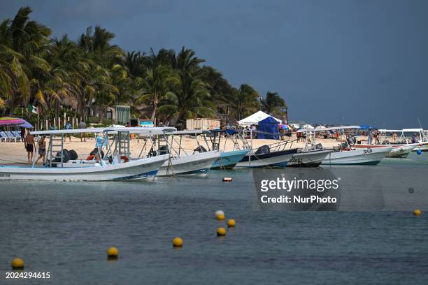 Fishing and tourist boats docked along the shore in Puerto Morelos, on December 17 in Puerto Morelos, Quintana Roo, Mexico.