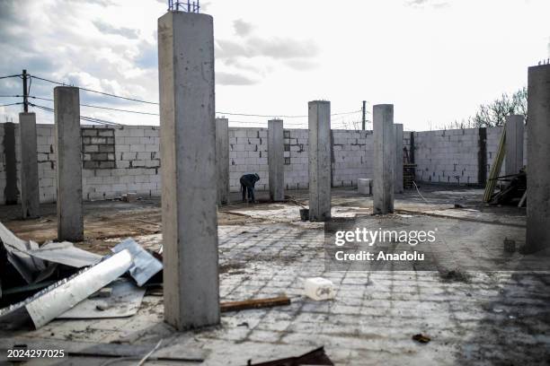 Man tries to repair the roof as Kyiv Oblast, surrounding the capital of Ukraine, still bears the scars of the war as the country marks the 2nd...