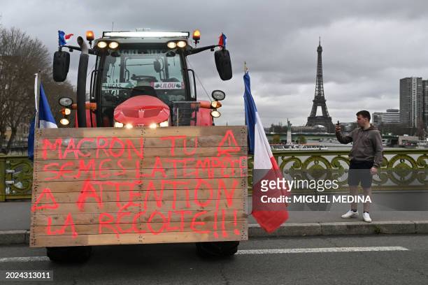 Man takes a picture of a tractor parked on the Pont Mirabeau with the Eiffel tower in the background during a farmers' demonstration ahead of the...
