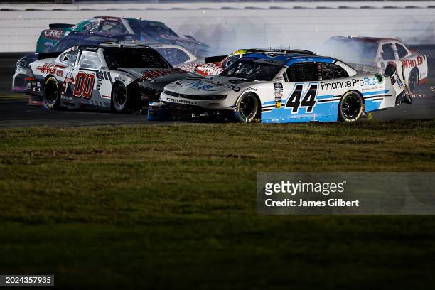Brennan Poole, driver of the Finance Pro Plus Chevrolet, and Cole Custer, driver of the Haas Automation Ford, spin into the infield grass after an...