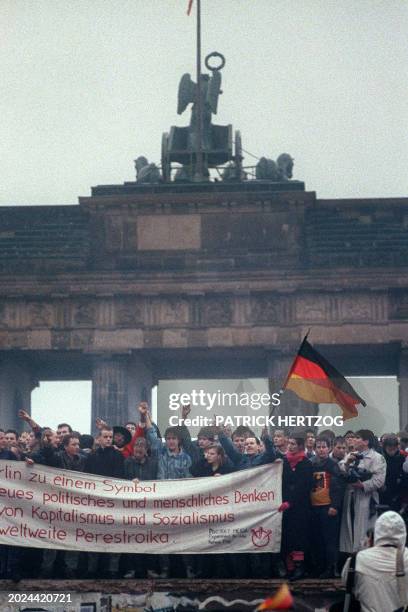 People from East Germany and West Germany gather for the opening of the Brandenburg Gate in Berlin on December 22, 1989. On November 09, Gunter...