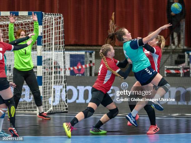 Polina Chernienko №5 of HC Sumy-U throws the ball, playing against Anastasiya Parkhomenko №4 and Karina Tovtyn №8 of HC Spartak Kyiv during the...