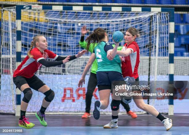 Anastasiya Parkhomenko №4 and Yuliya Nechayeva №66 of HC Spartak Kyiv stop Polina Chernienko №5 of HC Sumy-U from throwing the ball into the net...