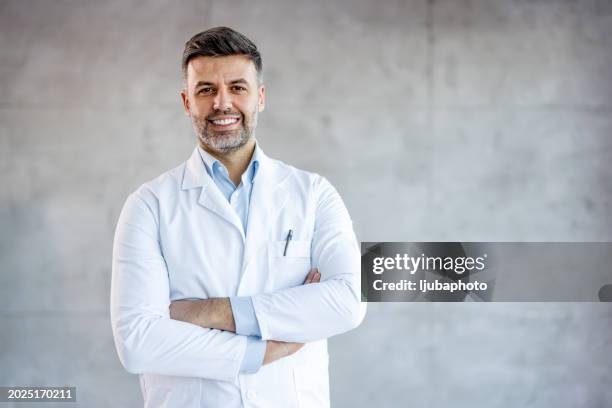cheerful mature doctor posing and smiling at camera, healthcare and medicine - bata de laboratorio fotografías e imágenes de stock