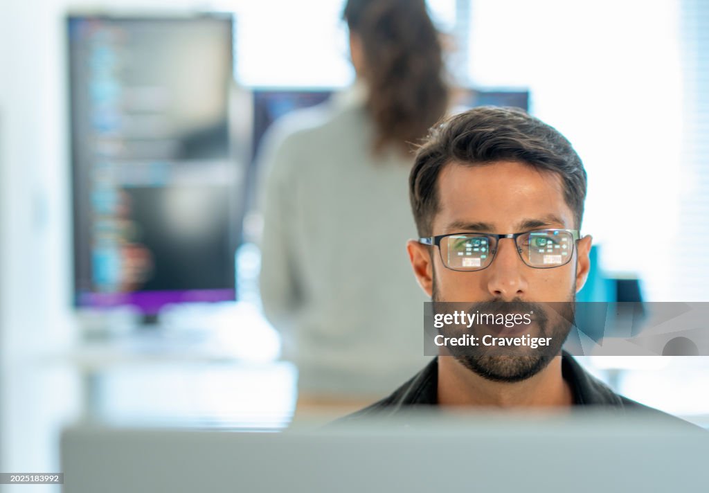 Males programmer in Working on desktop Computer with multiple screens work remotely at home. Programmer Typing Code, Creating Modern Software, e-Commerce App Design , Programmer development concept.