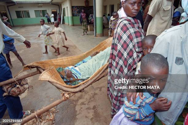 An elderly woman lies in a rustic bed waiting for medical attention in a hospital on August 20, 1994 in Cyangugu in the French "safety zone",...
