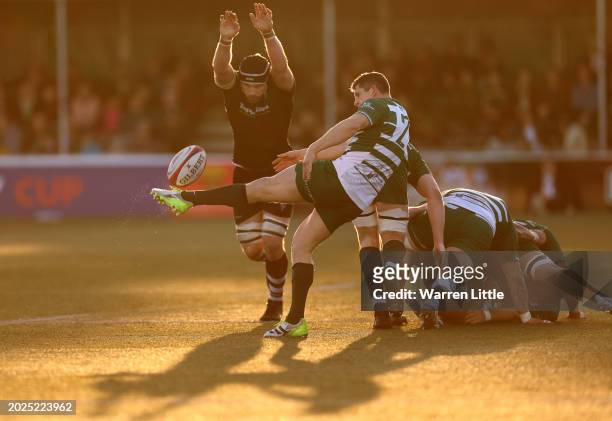 Matt Cornish of Ealing Trailfinders kicks the ball as he is challenged by Harry Wells of Leicester Tigers during the Premiership Rugby Cup match...