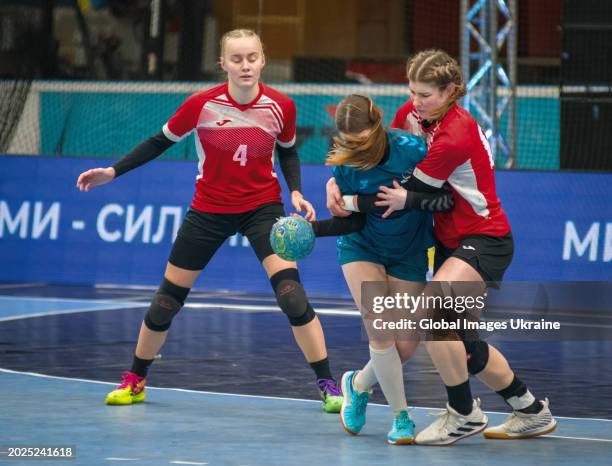 Daria Yakubovych №15 of HC Sumy-U fights for the ball against Anastasiya Parkhomenko №4 and Yuliya Nechayeva №66 of HC Spartak Kyiv during the...