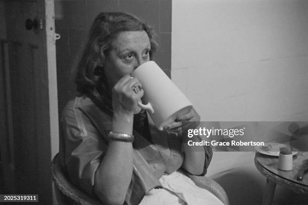 Client drinks from a large mug at the Savoy, a women's Turkish bath on Duke of York Street, London, UK, 1951. Original Publication: Picture Post -...