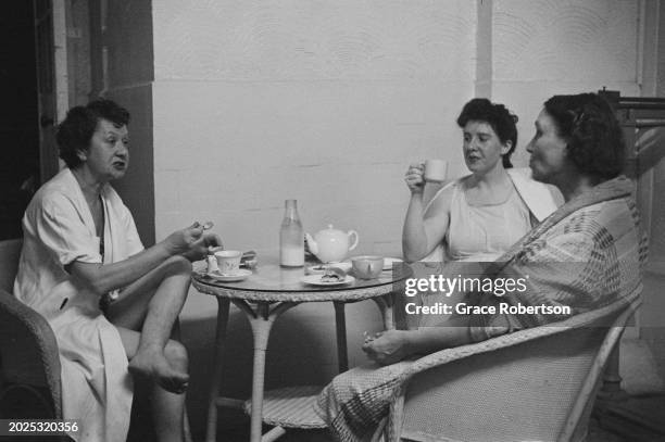 Staff chatting while on a break drinking tea at the Savoy, a women's Turkish bath on Duke of York Street, London, UK, 1951. Original Publication:...