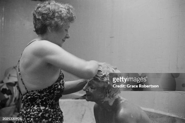 An employee shampooing a client at the Savoy, a women's Turkish bath on Duke of York Street, London, UK, 1951. Original Publication: Picture Post -...