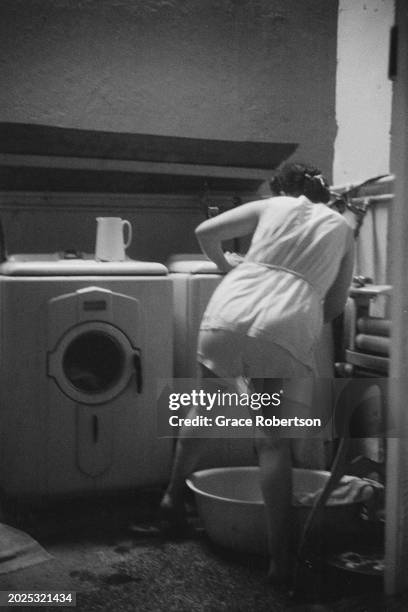 An employee of the Savoy, a women's Turkish bath on Duke of York Street, doing the laundry, London, UK, 1951. Original Publication: Picture Post -...