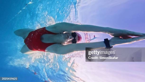 skilled female swimmer practicing in red swimwear at resort - sport determination stock pictures, royalty-free photos & images