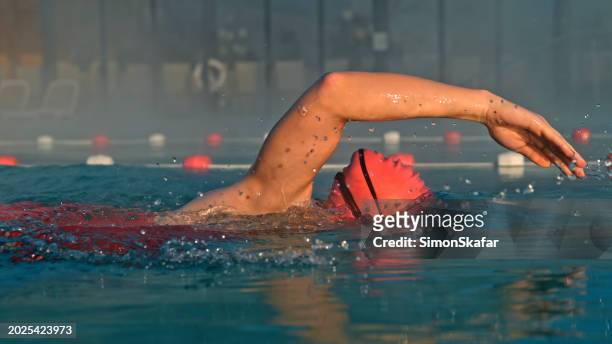 dedicated female swimmer practicing swimming techniques in pool - water sport stock pictures, royalty-free photos & images