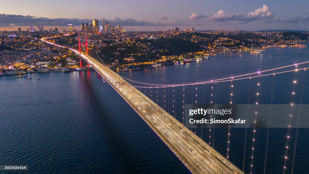 Luftaufnahme der beleuchteten Bosporus-Brücke über das Marmarameer durch Stadtbild während der Dämmerung in Istanbul, Türkei