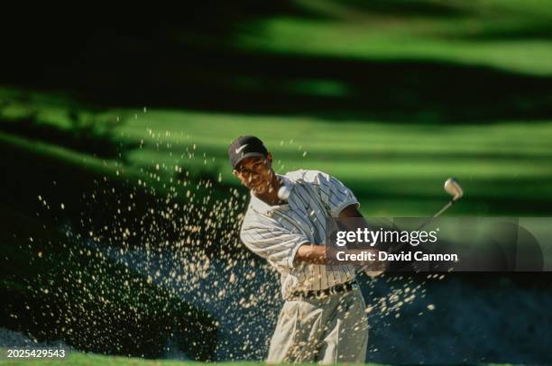 Tiger Woods from the United States follows his chip shot out of the sand trap during the first round of the 62nd US Masters Tournament on 9th April...