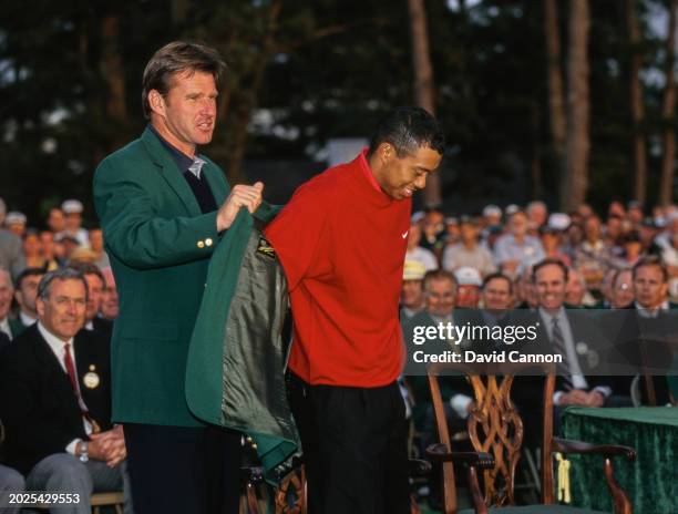 Tiger Woods from the United States is presented with the Masters Green Jacket from previous winner Nick Faldo after winning the 61st US Masters...