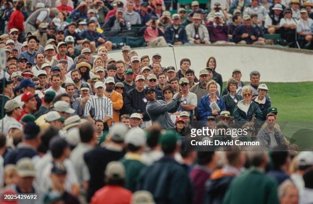 Spectators look on as Tiger Woods from the United States follows his iron shot off the tee during the third round of the 64th US Masters Tournament...