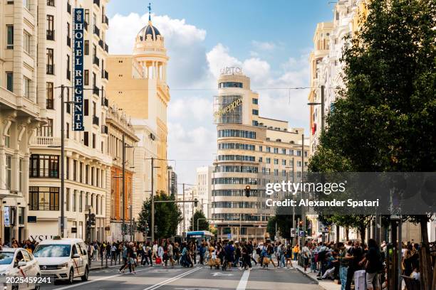 crowds of people on gran via avenue on a sunny day, madrid, spain - madrid stock pictures, royalty-free photos & images
