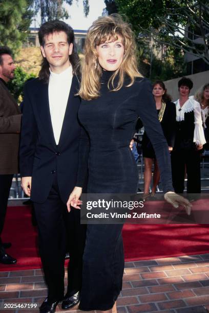 American singer and guitarist Lang Scott, wearing a black suit over a white shirt, and his wife, American singer Linda Davis, who wears a black...