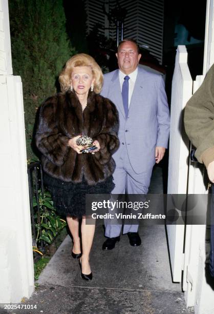 American philanthropist Barbara Davis, wearing a brown fur coat, and her husband, American industrialist Marvin Davis, who wears a light grey suit...