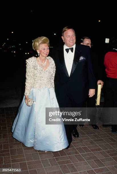 American philanthropist Barbara Davis, wearing a gold brocade jacket over a pale blue evening gown, and her husband, American industrialist Marvin...