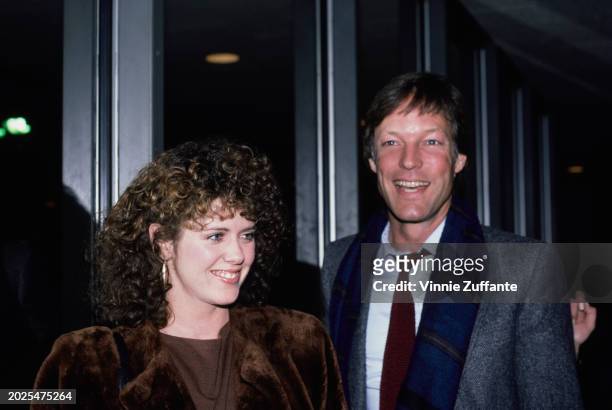 American actress Pam Dawber, wearing a brown fur coat, and American actor Richard Chamberlain, who wears a grey jacket over a shirt and tie with a...