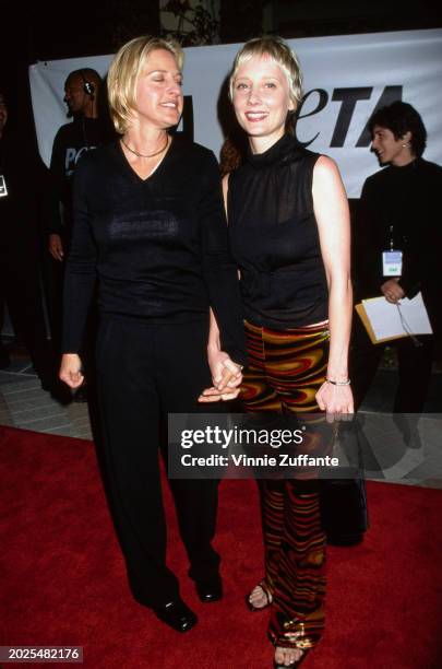 American television host and comedian Ellen DeGeneres, wearing a black v-neck sweater, and American actress Anne Heche, who wears a sleeveless black...