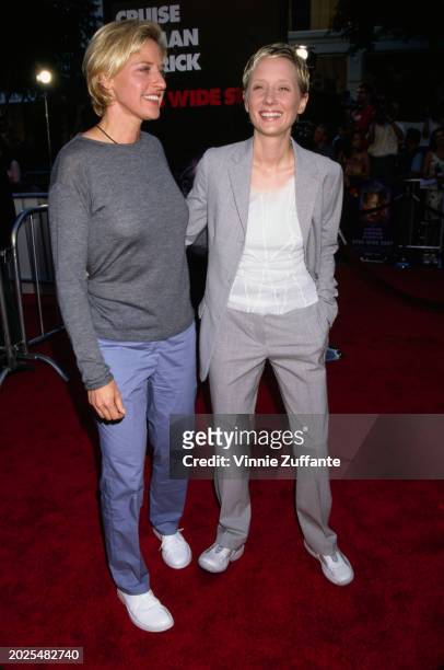 American television host and comedian Ellen DeGeneres, wearing a grey crew neck top and jeans, and American actress Anne Heche, who wears a grey suit...