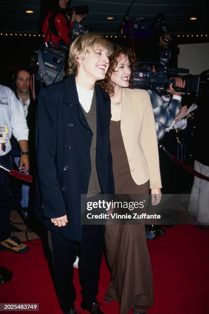 American television host and comedian Ellen DeGeneres, wearing a dark blue jacket over a grey sweater and a white crew-neck top, and American actress...