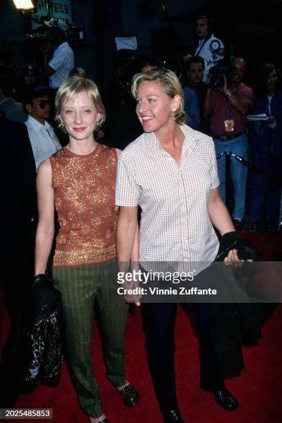 American actress Anne Heche, wearing a peach-coloured sleeveless jewel neck top with gold trim and green striped trousers, and American television...