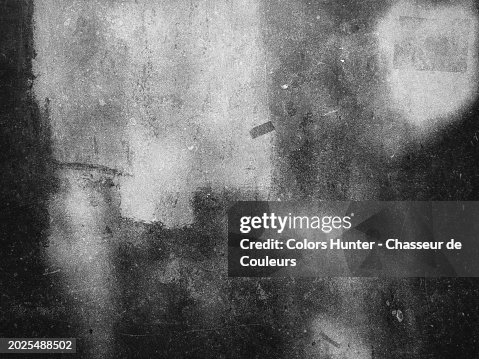 White paint on a gray and dirty stone wall in Brussels, Belgium. Sunlight and shadow. Black and white photograph. White paint on a gray and dirty stone wall in Brussels, Belgium. Sunlight and shadow. Black and white photograph.