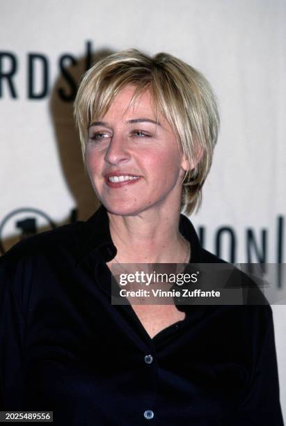 American television host and comedian Ellen DeGeneres, wearing a black shirt with an open collar, attends the 1998 VH1-Fashion Awards, held at...